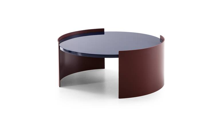 The Bowy coffee tables by Patricia Urquila for Cassina have a sleek, round design with simple minimalist lines. They come in two different finishes: a glossy lacquered finish reminiscent of the 1970s or a more rustic, textured wooden top.