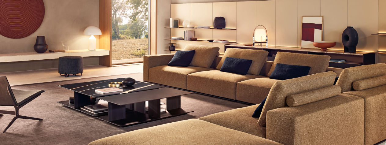 The Westside Sofa by Poliform has a commanding presence, with a wide, sturdy base that anchors it firmly to the ground . It is featured in a natural colour with contrasting tones in a contemporary living room.