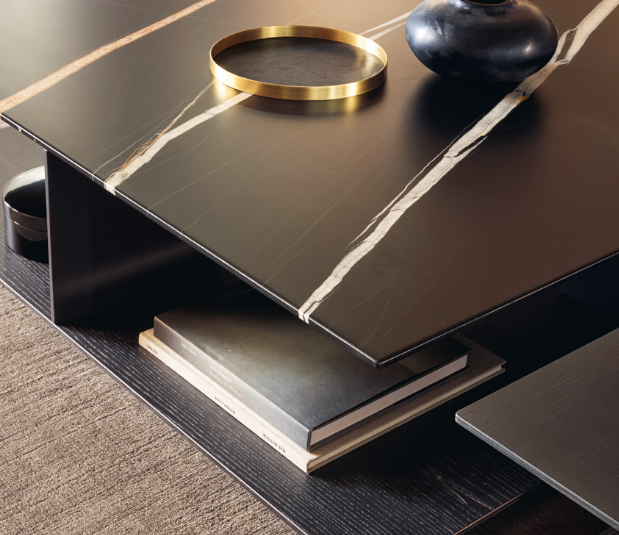 The Westside Coffee Table, designed by Jean-Marie Massaud for Poliform, is a masterful blend of materials and shapes. The unique base detail design allows for a half-peek through effect, creating an interesting visual appeal and providing a space for decor items to be displayed. Shown here in marble and timber finishes.