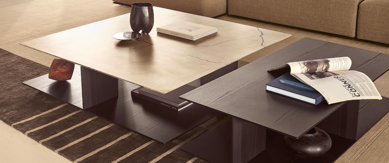 The Westside Coffee Table, designed by Jean-Marie Massaud for Poliform, is a masterful blend of materials and shapes. The unique base detail design allows for a half-peek through effect, creating an interesting visual appeal and providing a space for decor items to be displayed. Shown here in marble and timber finishes.